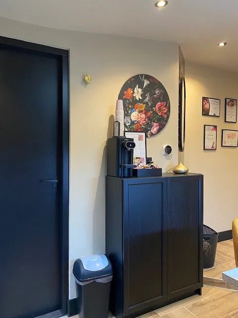 Salon met zwarte kast en koffiemachine